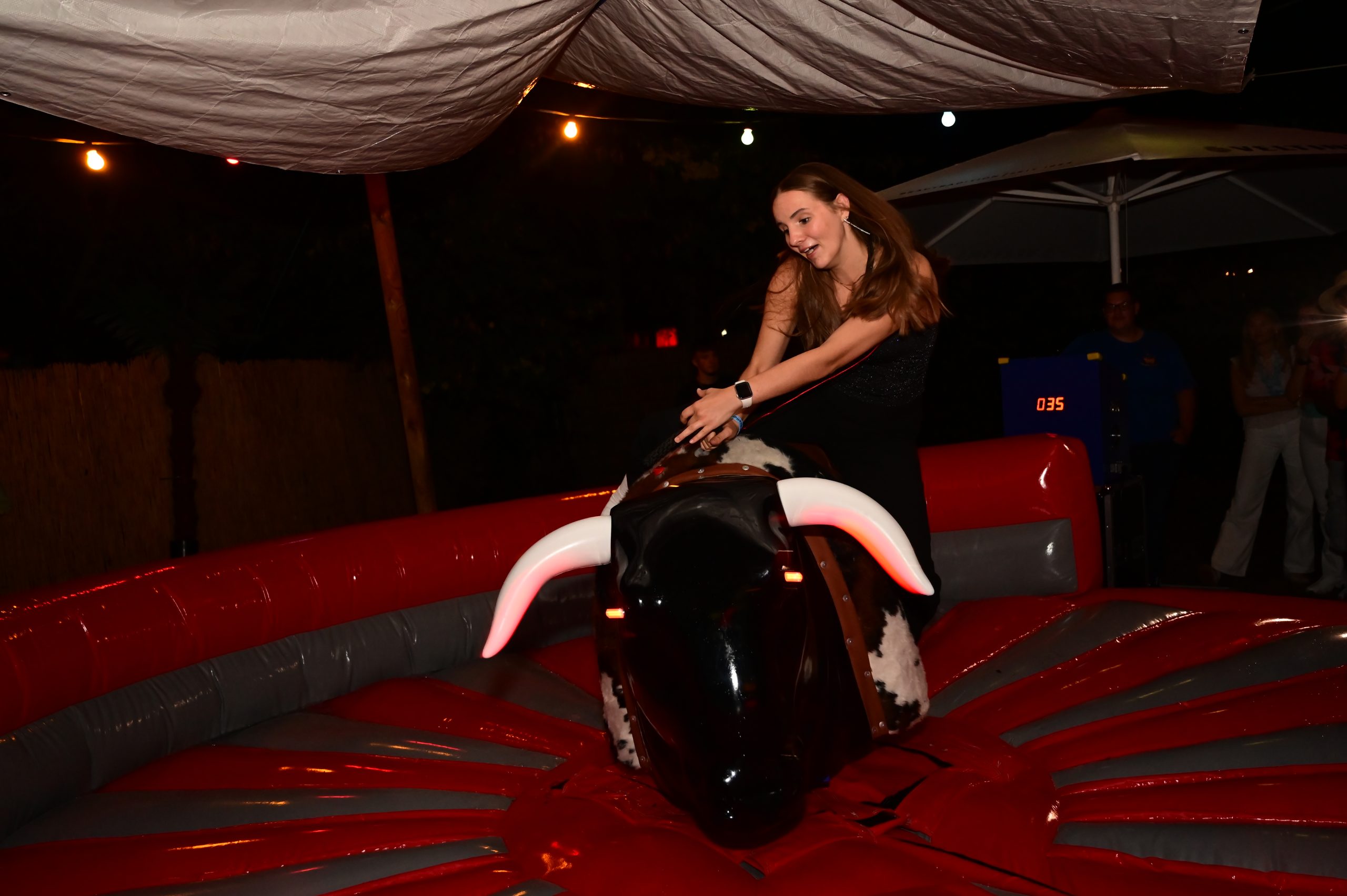 Frau fährt lachend auf dem Rodeobullen